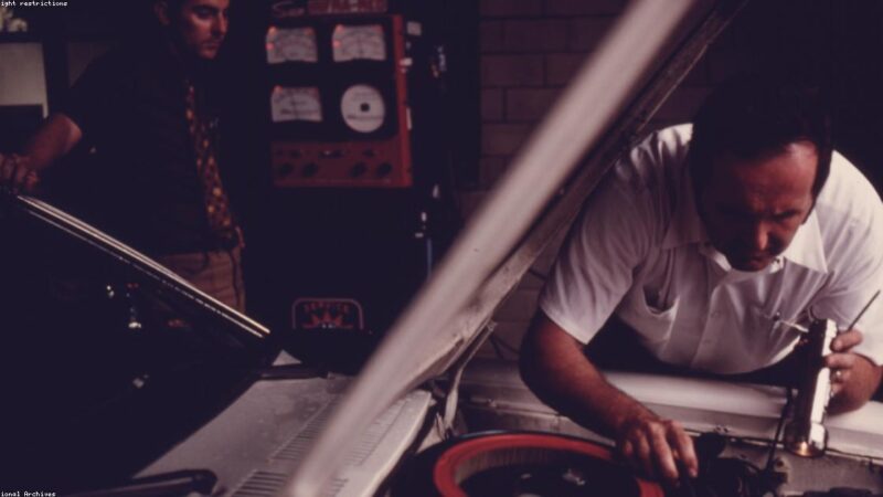 Mecânico inspecionando estrutura de carro usado em oficina especializada