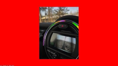 Camera de re instalada na placa traseira de carro com tela mostrando estacionamento