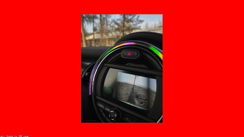 Camera de re instalada na placa traseira de carro com tela mostrando estacionamento