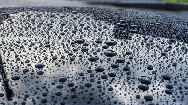 Kit completo de produtos de limpeza automotiva sobre o capo de um carro