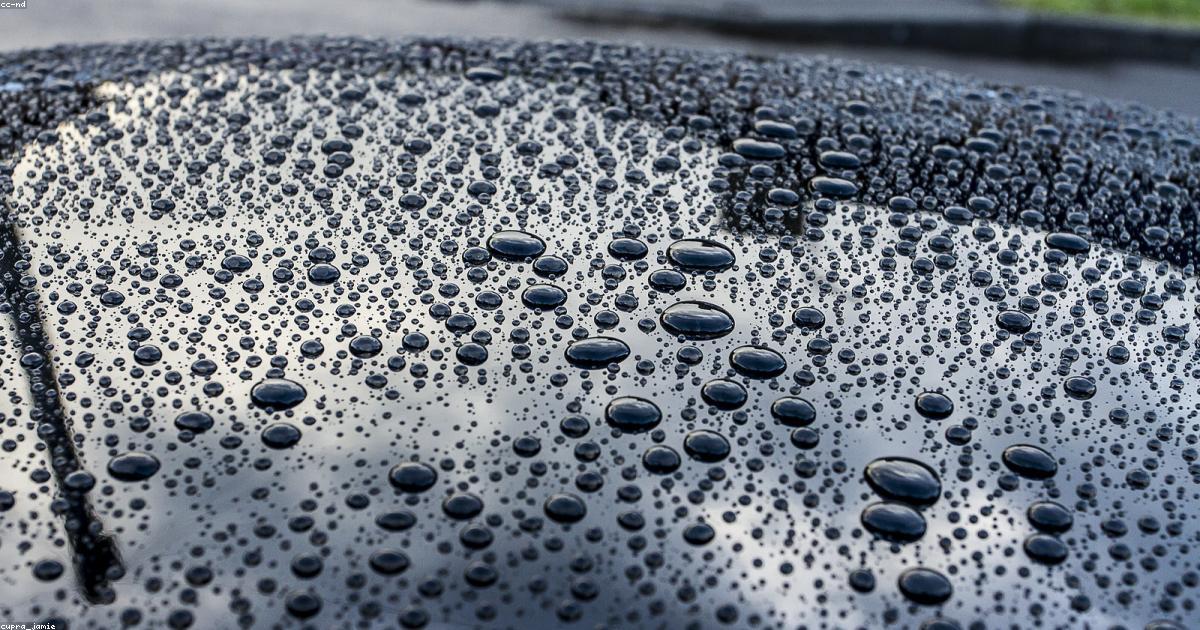 Kit completo de produtos de limpeza automotiva sobre o capo de um carro