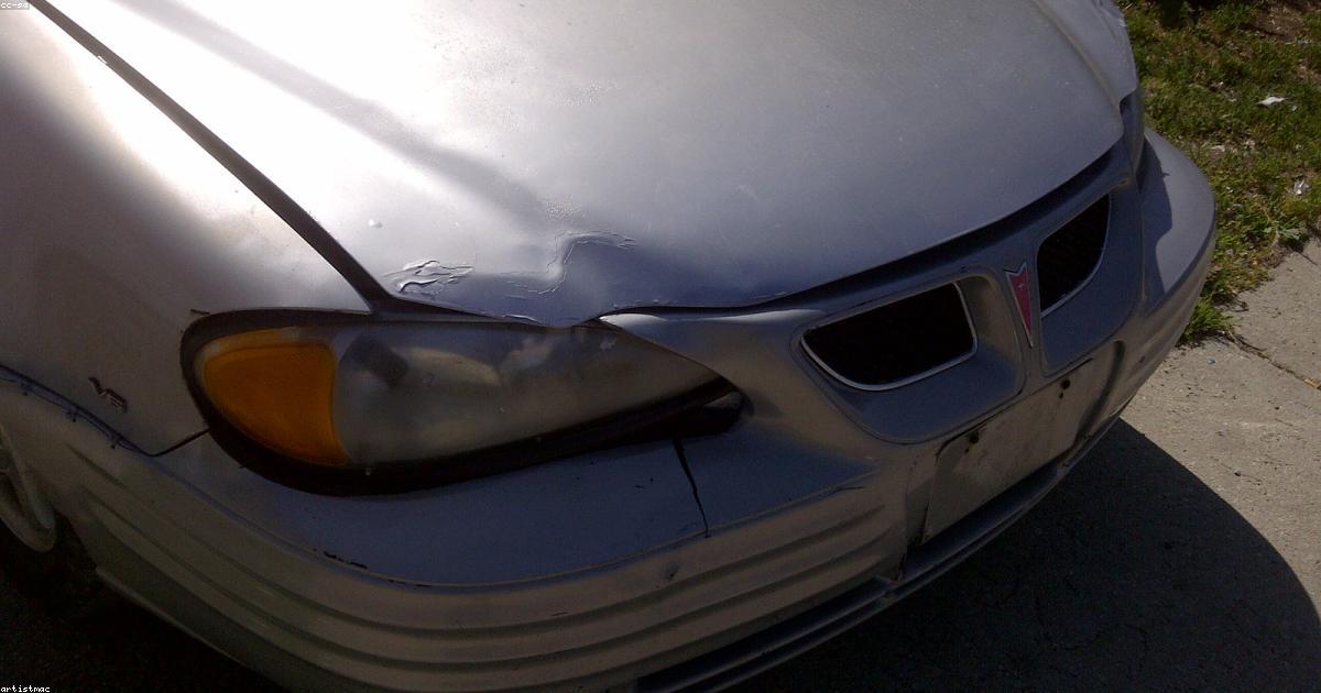 Vendedor entregando chaves de carro usado para comprador em estacionamento
